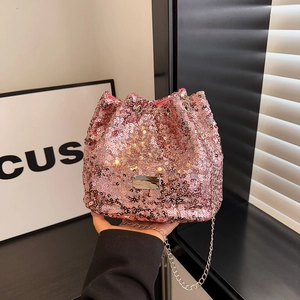 Detailed view of pink sequin bucket bag with silver metal logo and chain strap