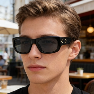 Detail of square black sunglasses with four golden star accents on the temple for men