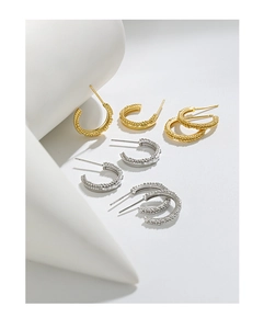 Macro detail of S925 sterling silver C-shaped hoop earrings with beaded texture finish