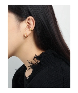 Detailed close-up of textured gold C-shaped hoop earrings and polished ear cuff for women