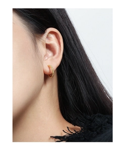 Detail of C-shaped golden beaded texture hoop earrings in S925 sterling silver on ear