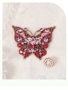 Detail of vintage gold butterfly brooch with colorful rhinestones and pearl flower pin