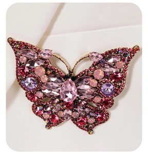 Close-up of luxury butterfly brooch with pink crystals and intricate gold metalwork