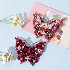 Elegant crystal butterfly brooch in pink and magenta tones with vintage gold plating