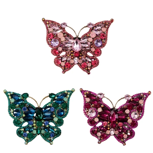 Three elegant crystal butterfly brooches in pink, blue, and purple colors with rhinestones
