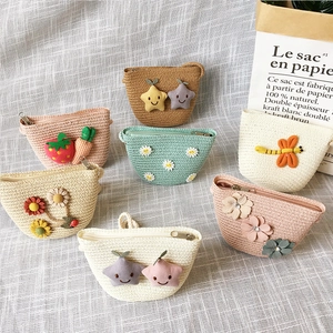 Detail of woven straw coin purses for kids with 3D cartoon flower and fruit decorations