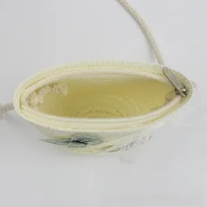 Internal view of a cute straw crossbody bag for kids with zipper and green floral patch
