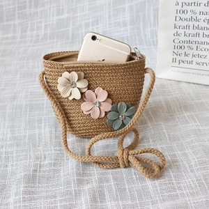 Handwoven straw crossbody bag with floral accents and a rustic rope strap for kids
