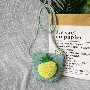 Close-up of light green woven children's crossbody bag with 3D pineapple decor