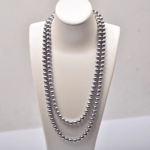 Detail of double-strand dark grey pearl necklace with metallic luster on jewelry bust