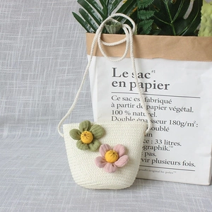 Détail du mini sac tissé crème pour filles avec fleurs décoratives et bandoulière fine