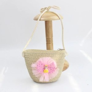 Detailed view of kids woven straw crossbody bag with pink tulle flower and cute doll