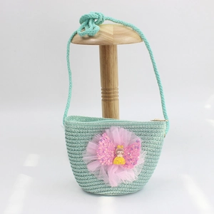 Detail of mint green straw bag for girls with a large pink sequin bow and doll charm