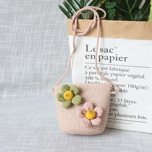 Détail d'un sac bandoulière rose tricoté pour enfant avec fleurs décoratives en 3D