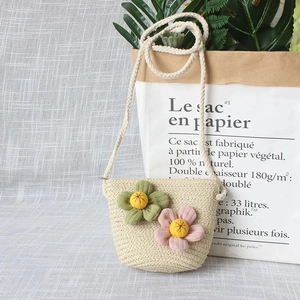 Détail de sac en paille pour enfant avec fleurs et bandoulière en corde souple