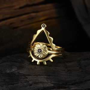 Macro detail of S925 sterling silver stamp and black gemstone on gold stackable eye ring