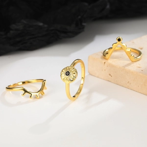 Three-piece stackable gold evil eye rings with black stone and adjustable opening