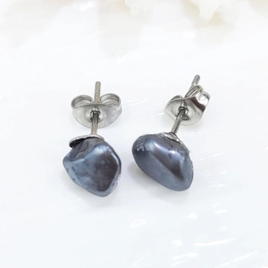 Macro shot of irregular black baroque pearl stud earrings with silver metal backing