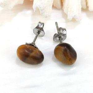 Macro shot of natural tiger eye stone earrings with irregular polished brown textures