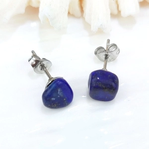Macro shot of irregular deep blue lapis lazuli stud earrings with natural stone texture