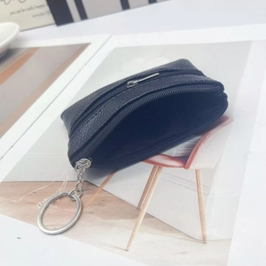 Dettaglio del mini portamonete nero a grana con doppia cerniera e anello portachiavi argento