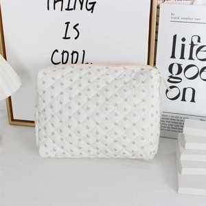 Close-up of white quilted floral cosmetic bag featuring delicate small flower patterns