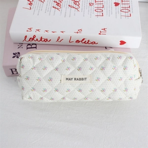 Close-up of quilted floral cosmetic bag with MAY RABBIT label and zipper detail