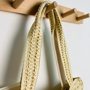 Detail of wide straw shoulder strap with intricate woven texture and reinforced stitching