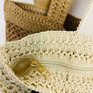 Detail of premium woven straw tote with high-quality metal zipper and beige fabric lining