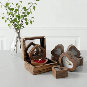 Detail of heart-shaped walnut ring box with a clear window and red velvet interior