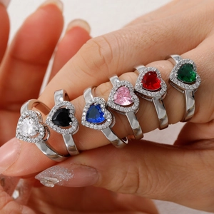 Close-up of adjustable silver rings with heart-shaped gemstones in multiple colors