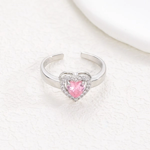 Detailed macro view of an adjustable heart ring with a pink crystal and cubic zirconia