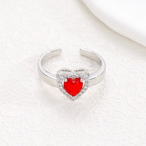 Macro detail of silver adjustable ring featuring a red heart zircon with diamond halo