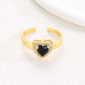 Detail shot of gold heart ring with black stone center and cubic zirconia halo