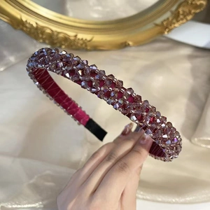 Macro shot of handmade beaded headband featuring lavender crystals on burgundy satin fabric