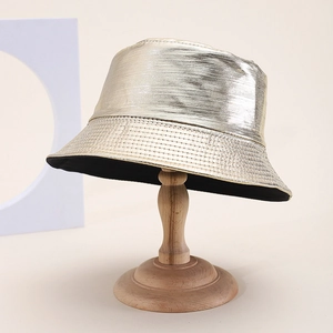 Detailed macro view of golden faux leather bucket hat texture on a wooden stand