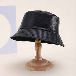 Modern black PU leather bucket hat with brushed texture and stitched brim on stand