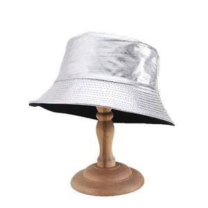 Metallic silver PU leather bucket hat with reflective finish and stitched brim on wooden stand