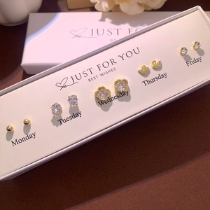 Detailed set of five gold plated stud earrings displayed in a luxury Monday to Friday gift box