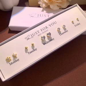 Close-up of 5-pair earring set for workdays with heart and star studs in a gift box