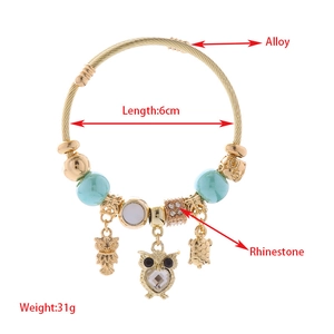 Charming owl and turtle charm bracelet with blue beads and rhinestones in gold finish