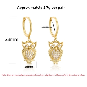 Macro view of gold owl earrings featuring micro-pave crystals and detailed texture