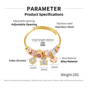 Detail showing gold heart bear charm bracelet with pink butterfly on stainless steel band