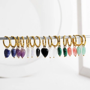 Detail of 18K gold earrings with multi-color heart-shaped natural stone pendants