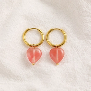 Detail of 18K gold hoop earrings featuring pink translucent heart-shaped stone pendants