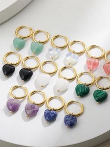 Detail of heart-shaped natural stone pendants on gold hoops in multiple colors