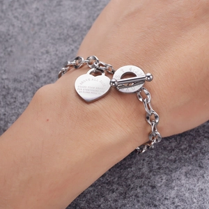 Détail du bracelet avec pendentif cœur gravé d'un verset et fermoir à bascule argenté