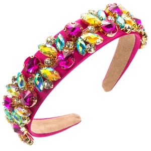 Dettaglio di un cerchietto largo in raso rosa con strass colorati e gemme luccicanti