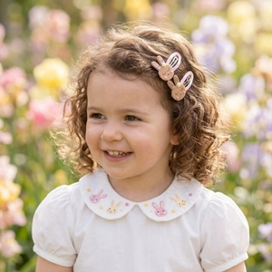 Detail of cute bunny hair clips with glitter and matching rabbit embroidery on shirt