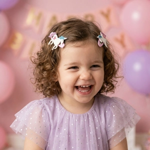 Cute unicorn hair clips worn by a young girl in a festive birthday party setting